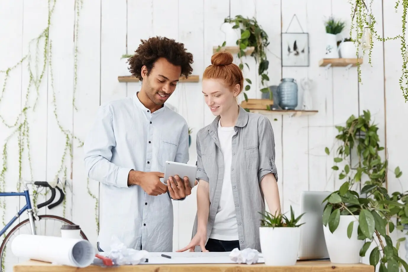 Porträt zweier kreativer Arbeitskräfte, die gemeinsam Blaupausen erstellen.
